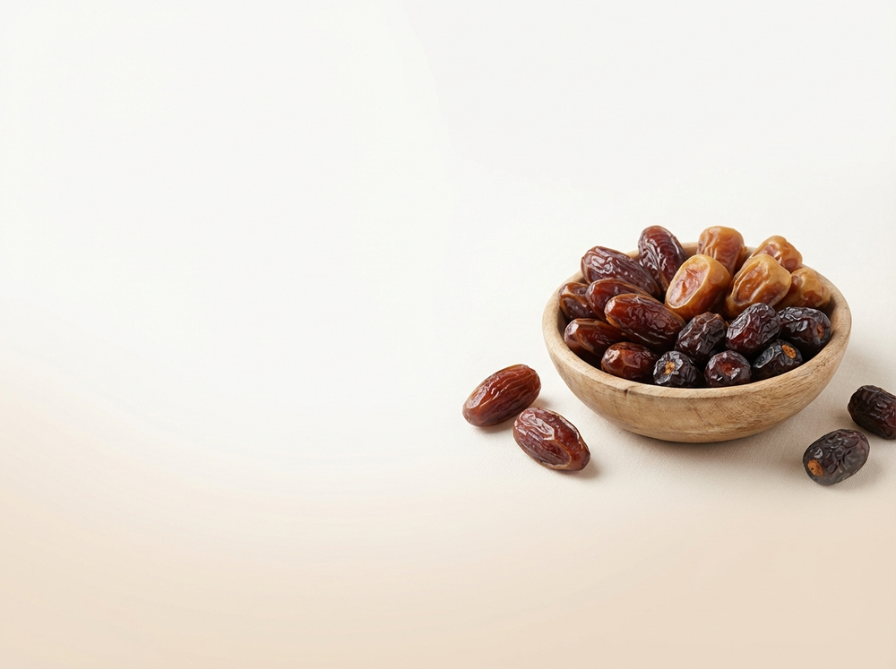 Wooden bowl filled with dates on a light beige background